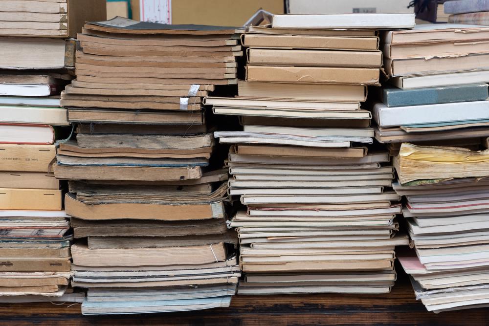 Stack of books in shelf collecting dust