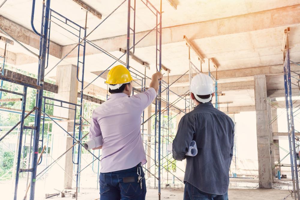 Project manager and engineer discuss layout plan onsite